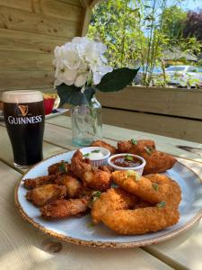a plate of food with shrimp on a table with a drink at Castle Arch Hotel in Trim