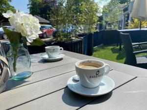 two cups of coffee sitting on a wooden table at Castle Arch Hotel in Trim