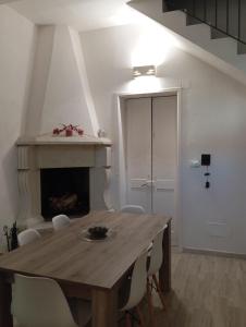 a dining room with a wooden table and a fireplace at Lapis Domus in Lecce