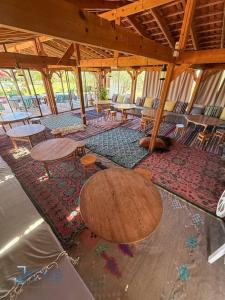 a large room with tables and chairs on a rug at Domaine Essanya Chalet and bungalows Nature quiet and private pool in Dawwār al Frinine