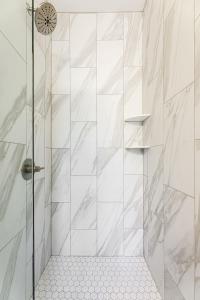 a bathroom with a shower with white tiles at Hamilton Place Sagewood Building 307 A in Traverse City +28 photos