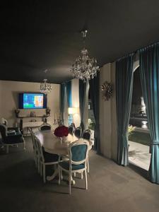 a dining room with a table and chairs and a chandelier at Villa Gyos in Costinesti