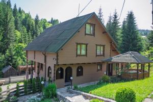 a large wooden house with a green roof at Апартаменти у Яни in Yablunytsya +8 photos