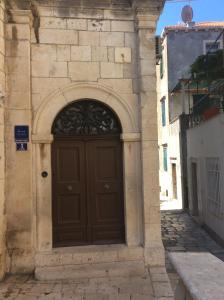 una puerta marrón en el lateral de un edificio en Rooms Pile, en Dubrovnik