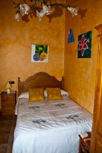 a bedroom with a bed with white sheets and yellow walls at Casa Rural Dos Infantas Las Lilas in Valdespino