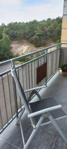 a bench on a balcony with a view of the ocean at Apartament Na Wydmie in Ustka