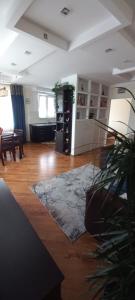 a living room with a table and a room with a rug at Apartament Na Wydmie in Ustka