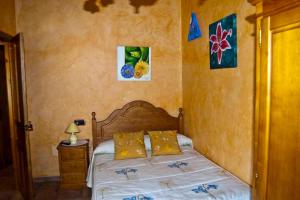 a bedroom with a bed and paintings on the wall at Casa Rural Dos Infantas Las Lilas in Valdespino