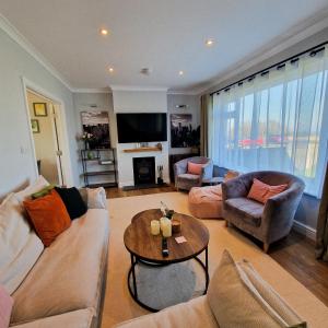 ein Wohnzimmer mit Sofa und Tisch in der Unterkunft Luxury Sea View Retreat with Hot Tub Sleeps 8 in Dover
