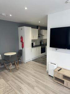 un soggiorno con tavolo e TV e una cucina di Noahs Corner a Milford Haven