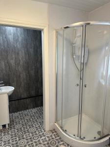 una doccia con una porta in vetro in un bagno di Noahs Corner a Milford Haven