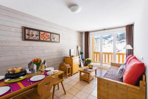 a living room with a table and a dining room at Résidence Lagrange Vacances L'Orée des Cîmes in Les Angles