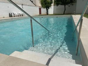 a swimming pool with blue water in a house at CENTRO, PARKING, PISCINA 2 Dormitorios SUITE PONDOS in Linares
