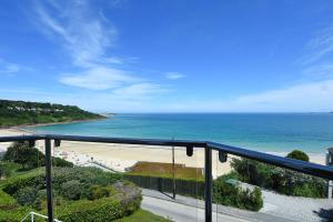 a view of a beach and the ocean from a balcony at Carn Brea in Redruth