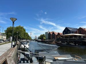a boat is docked at a dock on a river at Danės 5 apartament in Klaipėda