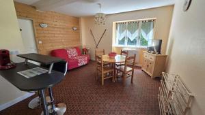 a small living room with a table and a couch at Maison 10 personnes Chez Perrine et Nicolas in La Bourboule