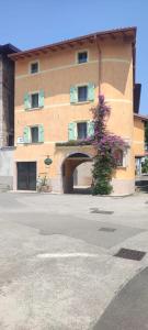 a building with a plant with purple flowers in front of it at Residenza Alice in Arco