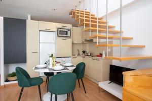 eine Küche und ein Esszimmer mit einem Tisch und grünen Stühlen in der Unterkunft SingularStays Edificio La Pergola in Castellón de la Plana