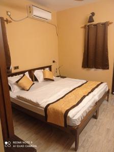 a bedroom with a bed with white sheets and a window at 2 bhk apartment goa baga in Assagao