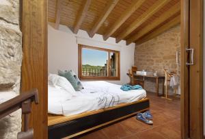 una camera da letto con un letto in una stanza con una finestra di Espacioso pajar con barbacoa - Casa de las Letras a Lledó
