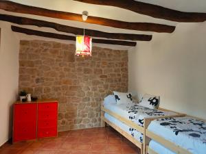 una camera da letto con due letti e un muro di mattoni di Espacioso pajar con barbacoa - Casa de las Letras a Lledó
