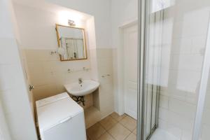 a white bathroom with a sink and a mirror at Apartments Fleischhauerstraße in Lübeck