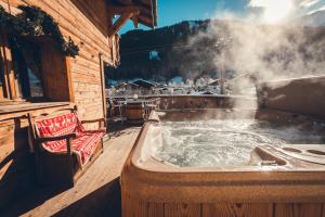 a hot tub on the deck of a cabin at Savoya Lodges, 4 chalets privés, de 2 à 40 personnes in Châtel