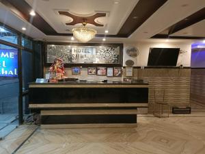 a restaurant with a bar and a tv in a room at Collection O Shri Mata Vaishno Devi Railway Junction Formerly Sai Mahal in Katra