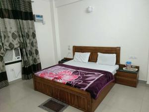 a bedroom with a bed with a purple blanket at Collection O Shri Mata Vaishno Devi Railway Junction Formerly Sai Mahal in Katra