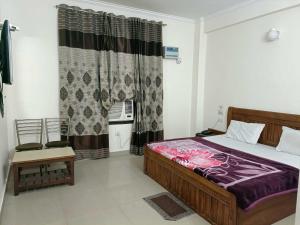 a bedroom with a bed and a window at Collection O Shri Mata Vaishno Devi Railway Junction Formerly Sai Mahal in Katra
