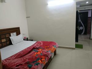 a bedroom with a bed with a red blanket at Collection O Shri Mata Vaishno Devi Railway Junction Formerly Sai Mahal in Katra