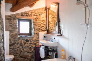 a stone bathroom with a sink and a mirror at Casa San Martino Lago Di Como in San Siro +50 photos