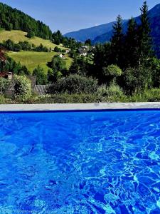 a large pool of blue water with mountains in the background at Haus St Peter , midden in meren gebied van Karinthië in Radenthein