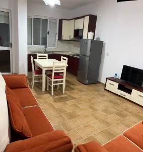 a living room with a couch and a table and a kitchen at Al mare! 01 in Shëngjin +4 photos