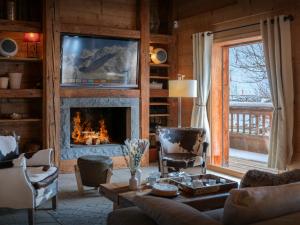 a living room with a fireplace and a tv at Chalet Le San Marco - OVO Network in La Clusaz