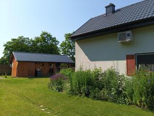 a barn and a house with a yard at Smocze Ranczo 3 in Ośno Lubuskie
