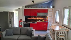 salon z kanapą i czerwoną kuchnią w obiekcie Das Gartenhaus - Lottstetten w mieście Lottstetten