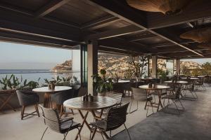 Un restaurante con mesas y sillas y vista al mar. en Büyük Hotel, en Alanya