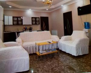 a room with two beds and a table in it at Gues House Aisi in Telavi