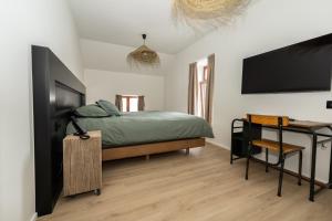 une chambre avec un lit et une télévision à écran plat dans l'établissement Hôtel de la Poste, à Gedinne
