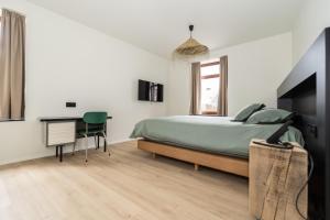 une chambre avec un lit et un bureau dans l'établissement Hôtel de la Poste, à Gedinne