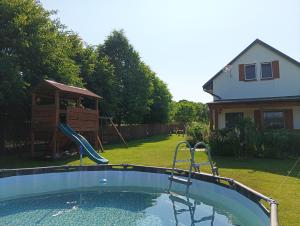 a swimming pool in a yard with a playground at Smocze Ranczo 3 in Ośno Lubuskie