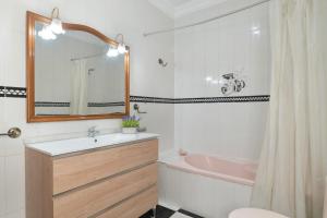 une salle de bain avec un lavabo, une baignoire et un miroir dans l'établissement Apartamento Elvira, à Conil de la Frontera 17 autres photos