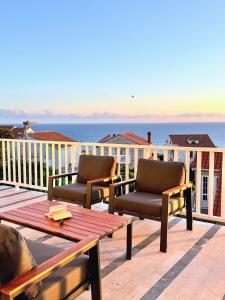 two chairs and a table on a deck with the ocean at Indigo Cavtat Apartments in Cavtat