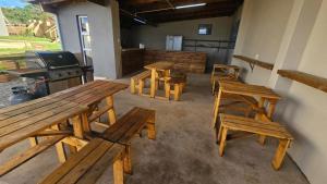 un grupo de mesas y bancos de madera en una habitación en Whales View self catering Elysium, en Elysium 9 fotos más