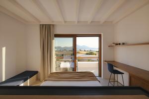 Ένα ή περισσότερα κρεβάτια σε δωμάτιο στο ROOTS Nature Living Milos