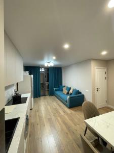 a living room with a blue couch in a kitchen at Shaika resort Bibllan apartmens in Chon-Sary-Oy +50 photos