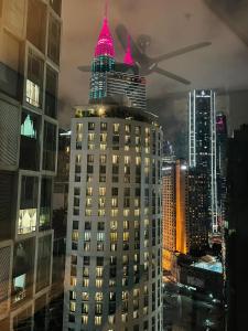 Un edificio alto con sombreros rosas en la parte superior. en Soho Suites KLCC by Comfort Suites Kuala Lumpur, en Kuala Lumpur