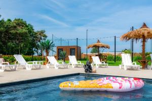 a pool with an inflatable raft in the water at Domki Piaskowa11 Palm Resort & Wellness - Basen, Jacuzzi, Balia, Sauna, Egzotyczne Papugi Ara in Łeba