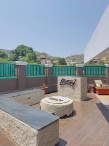 un patio avec une table et des bancs sur le toit dans l'établissement Dolally Pool and bar By villagram, à Lonavala